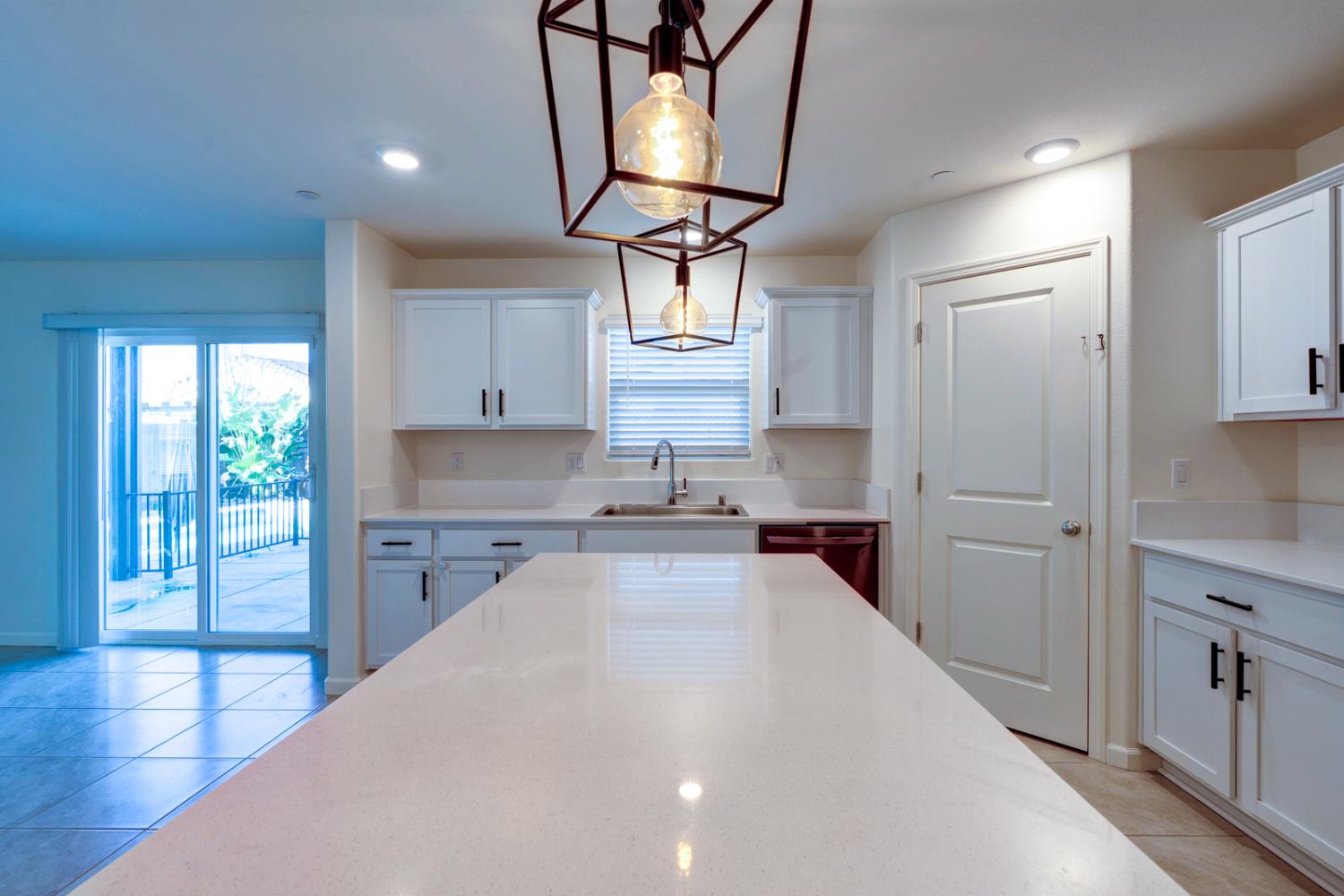 753 Heitz Way Merced, CA 95348 - Photo 25 of 70 a kitchen with granite countertop a stove a sink dishwasher and a refrigerator