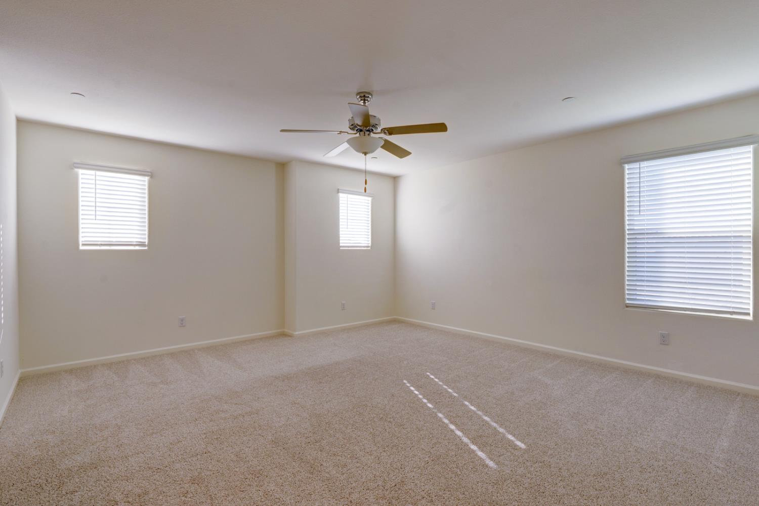 753 Heitz Way Merced, CA 95348 - Photo 36 of 70 an empty room with windows and chandelier fan