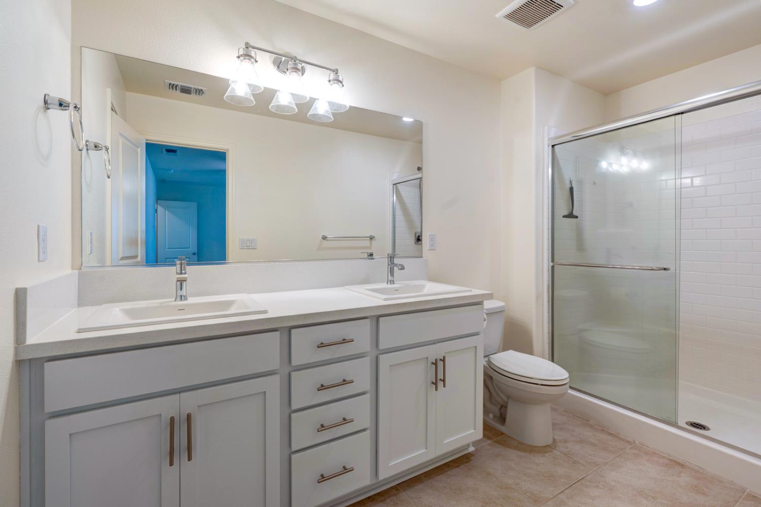 753 Heitz Way Merced, CA 95348 - Photo 41 of 70 a bathroom with a double vanity sink toilet and shower