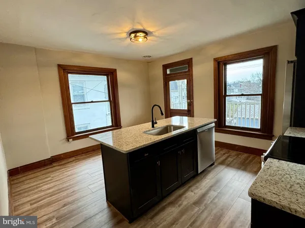 a kitchen with sink cabinets and wooden floor