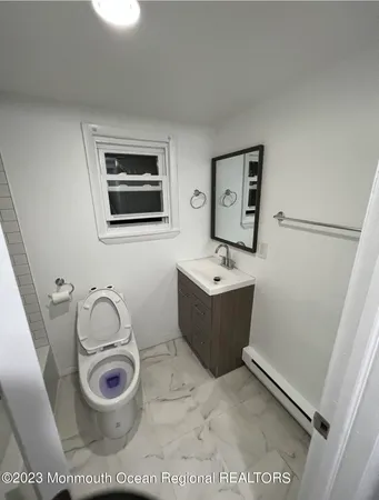 a bathroom with a toilet a sink a mirror and shower