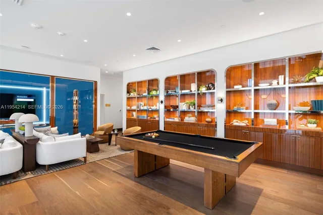 a living room with furniture pool table and a large window