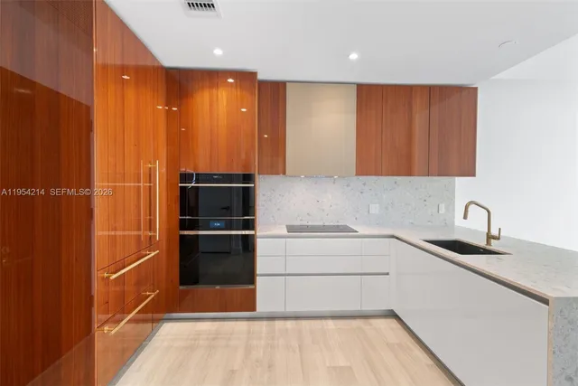 a kitchen with a sink cabinets stainless steel appliances and a counter top space