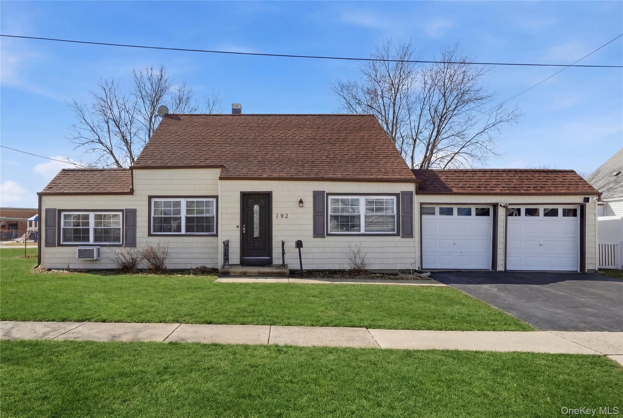 192 Mill Road Valley Stream, NY 11581 - Photo 1 of 26 a front view of a house with a yard and garage