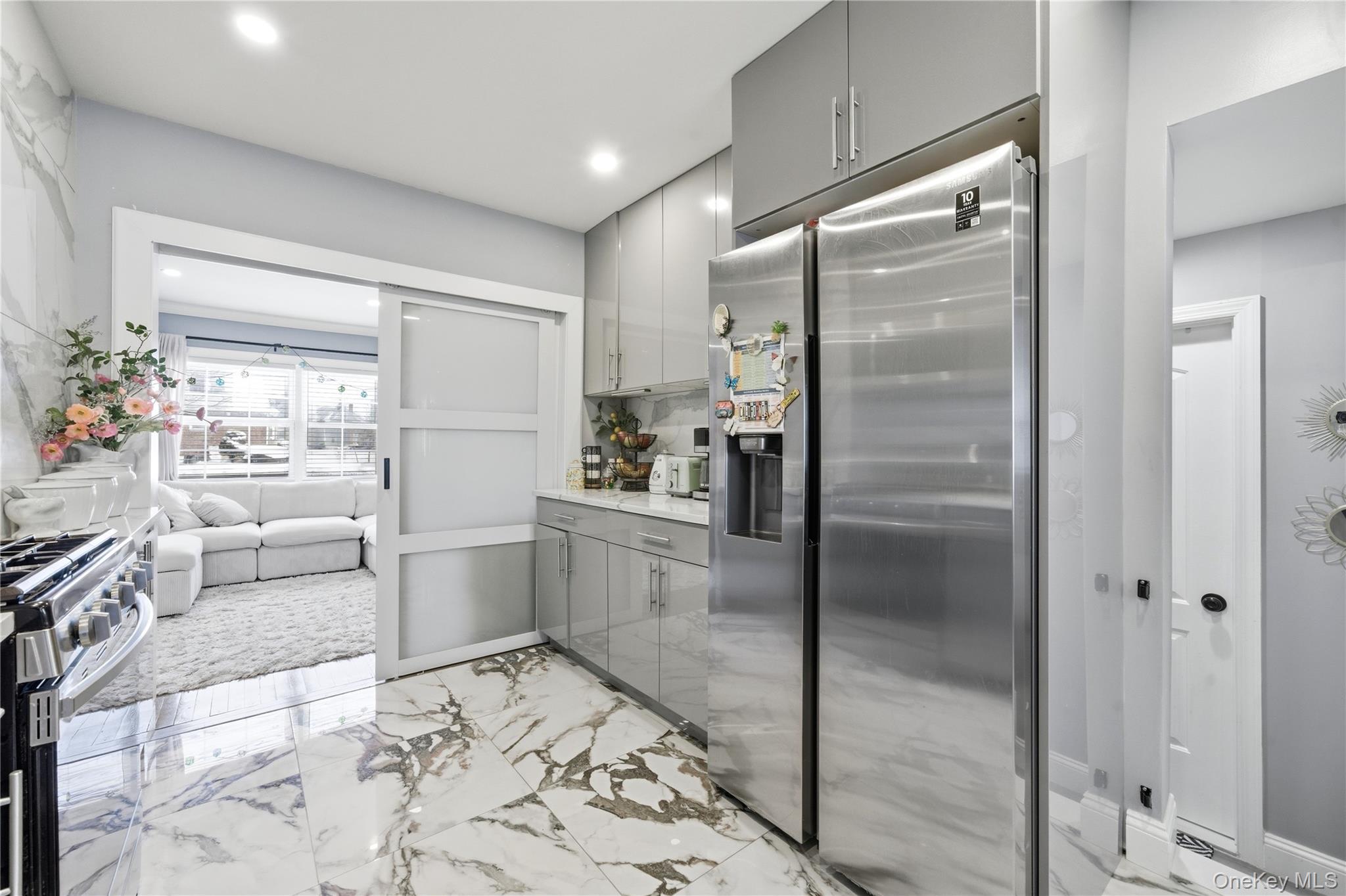 192 Mill Road Valley Stream, NY 11581 - Photo 13 of 26 a kitchen with a refrigerator and white cabinets