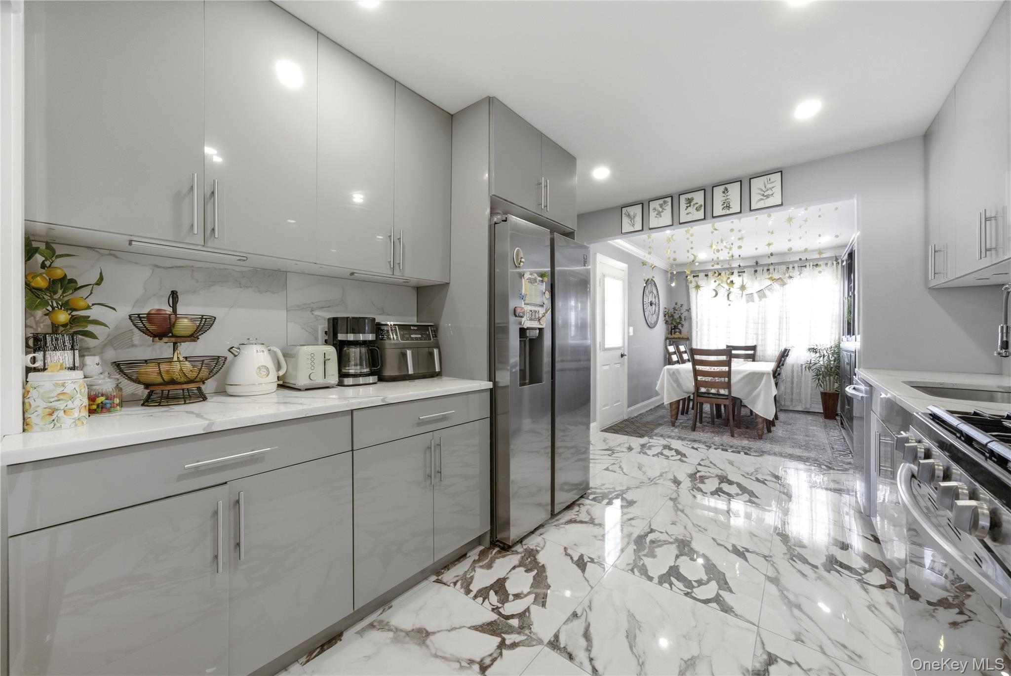192 Mill Road Valley Stream, NY 11581 - Photo 14 of 26 a kitchen with sink refrigerator and cabinets