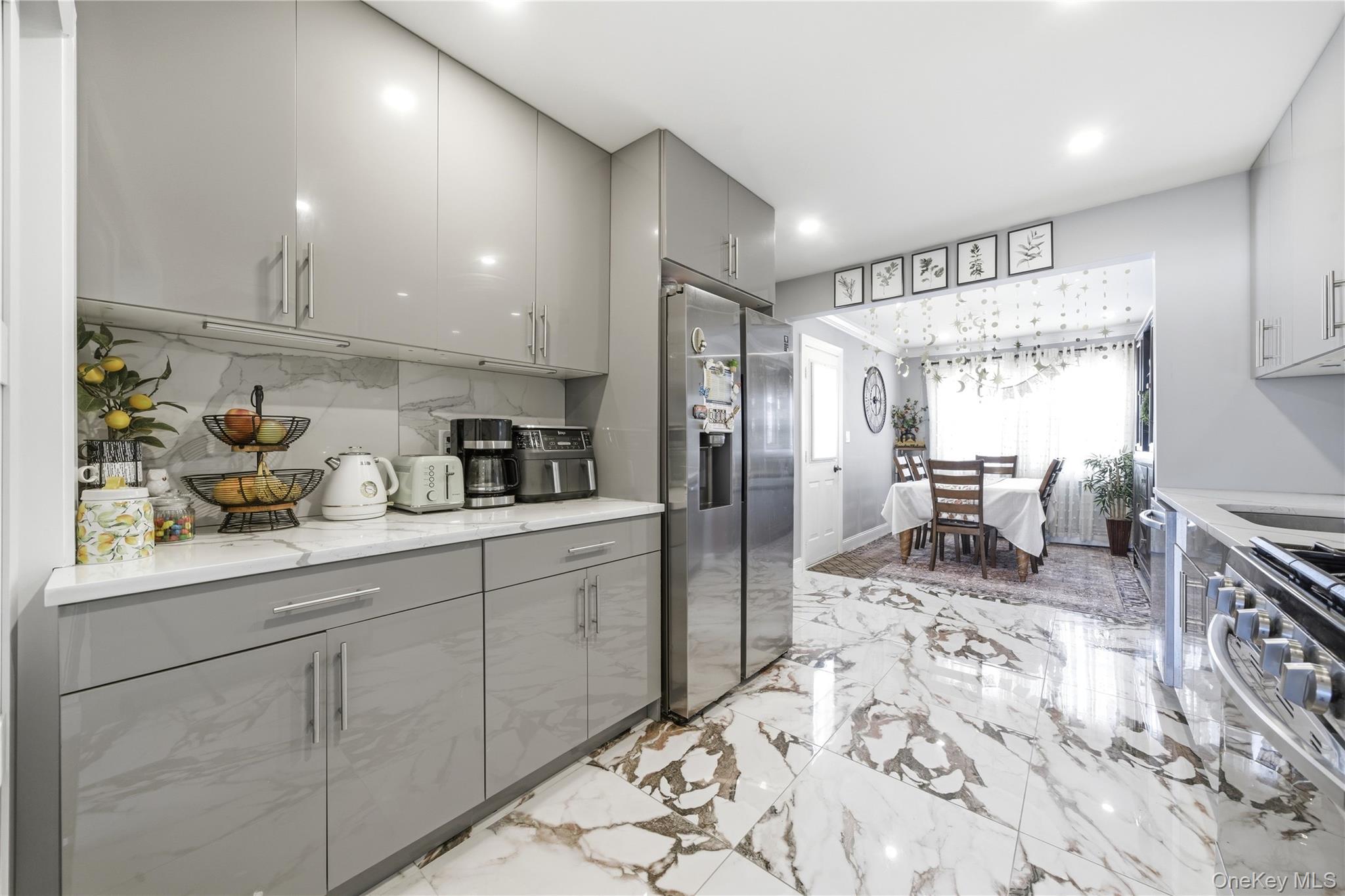 192 Mill Road Valley Stream, NY 11581 - Photo 15 of 26 a kitchen with stainless steel appliances kitchen island granite countertop a refrigerator and cabinets