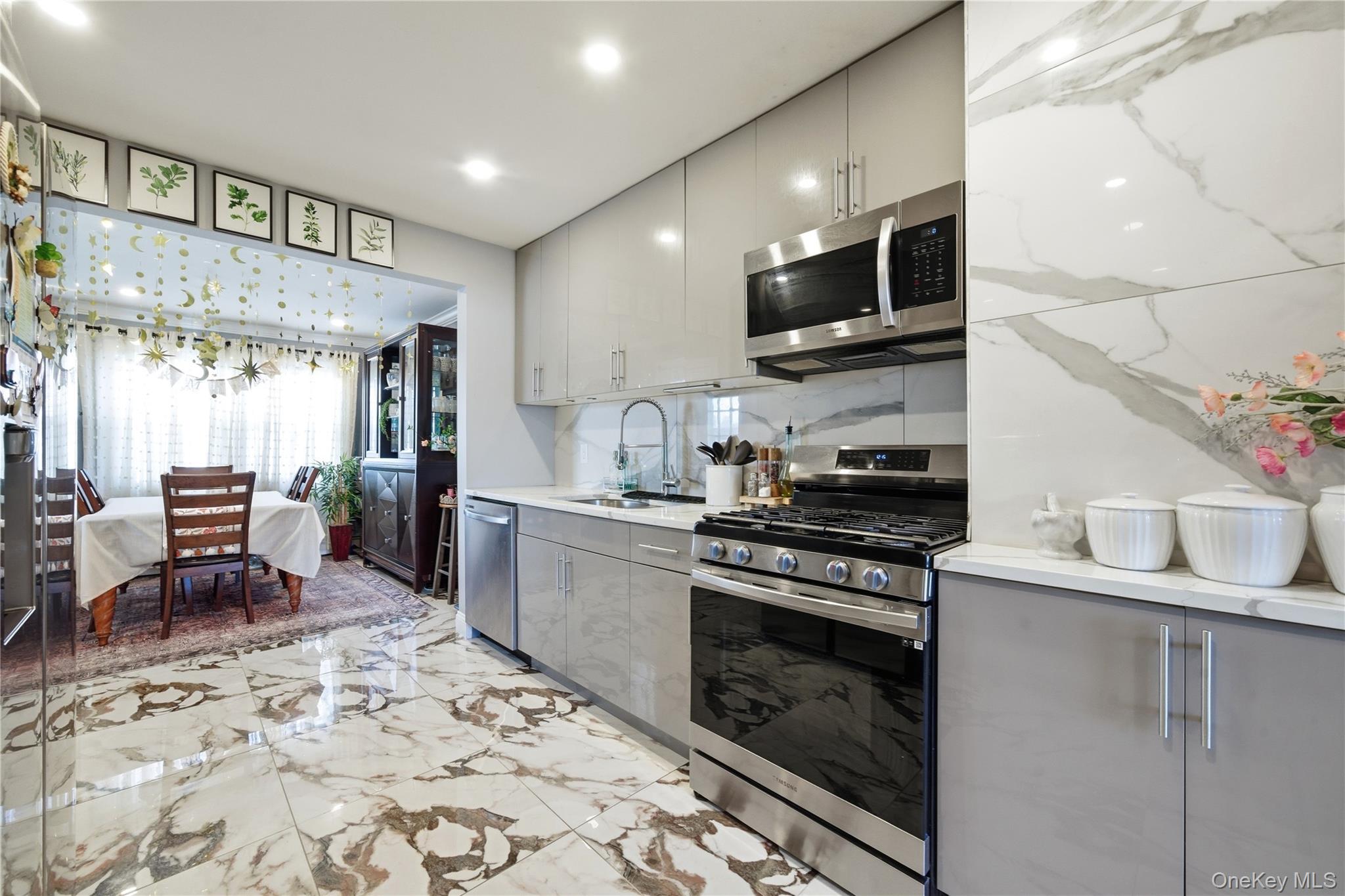 192 Mill Road Valley Stream, NY 11581 - Photo 16 of 26 a kitchen with stainless steel appliances granite countertop a stove top oven a sink dishwasher and a refrigerator with wooden floor