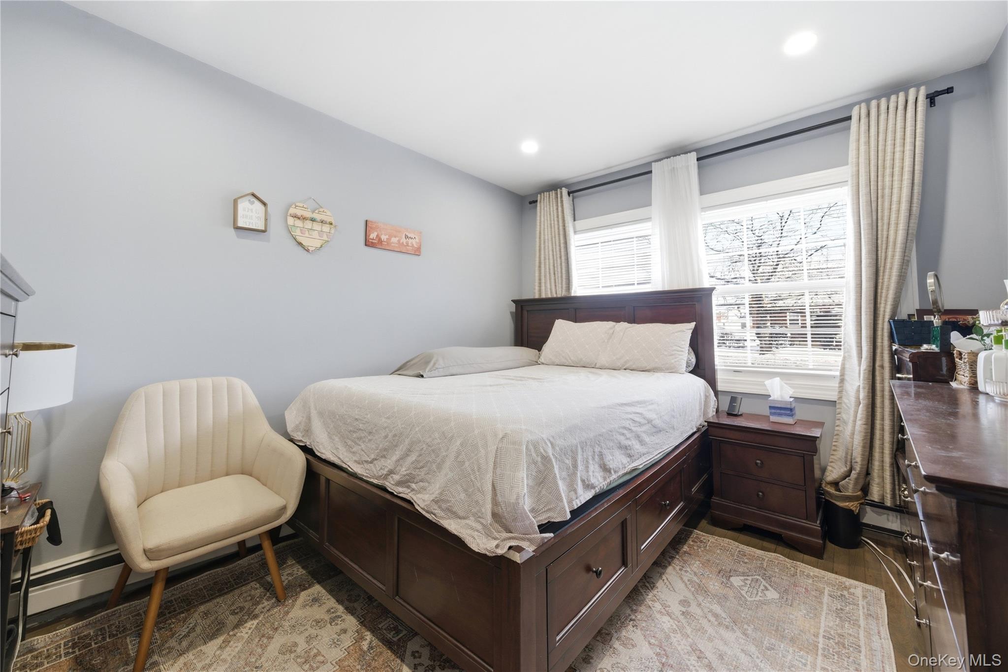 192 Mill Road Valley Stream, NY 11581 - Photo 8 of 26 a bedroom with a bed and a chair