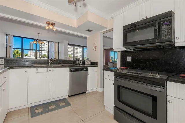 a kitchen with stainless steel appliances granite countertop a stove microwave and sink