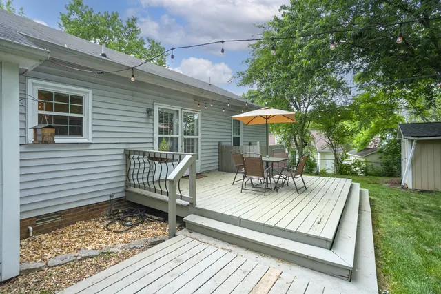 a view of a patio with a table chairs and a barbeque