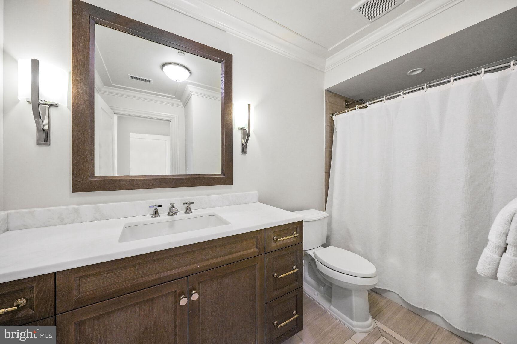 6900 Fleetwood Road, Unit 401 McLean, VA 22101 - Photo 22 of 29 a bathroom with a toilet sink and mirror