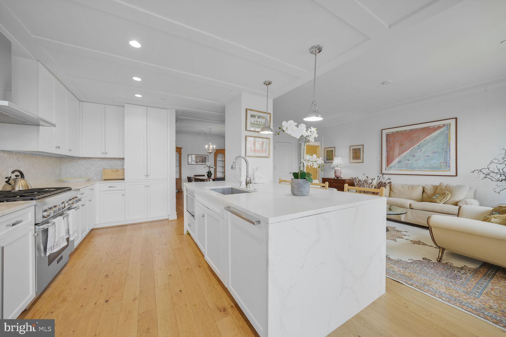 6900 Fleetwood Road, Unit 401 McLean, VA 22101 - Photo 10 of 29 a large white kitchen with kitchen island a stove a sink a center island and couches