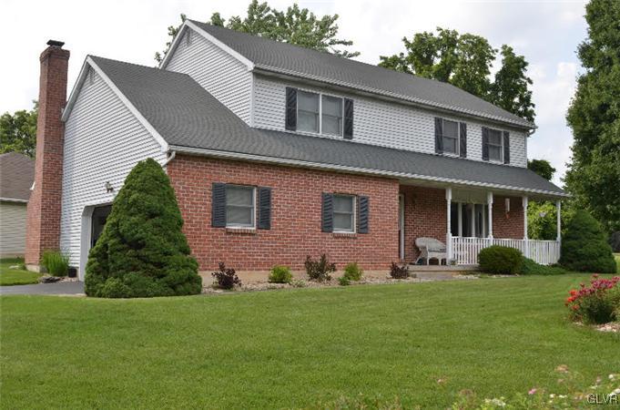 a front view of a house with a garden and yard