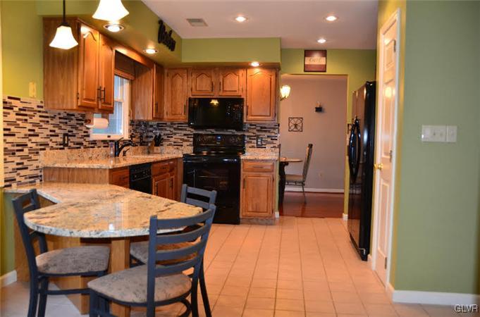 3305 Fischer Road Easton, PA 18045 - Photo 2 of 16 a kitchen with stainless steel appliances a dining table chairs and a refrigerator