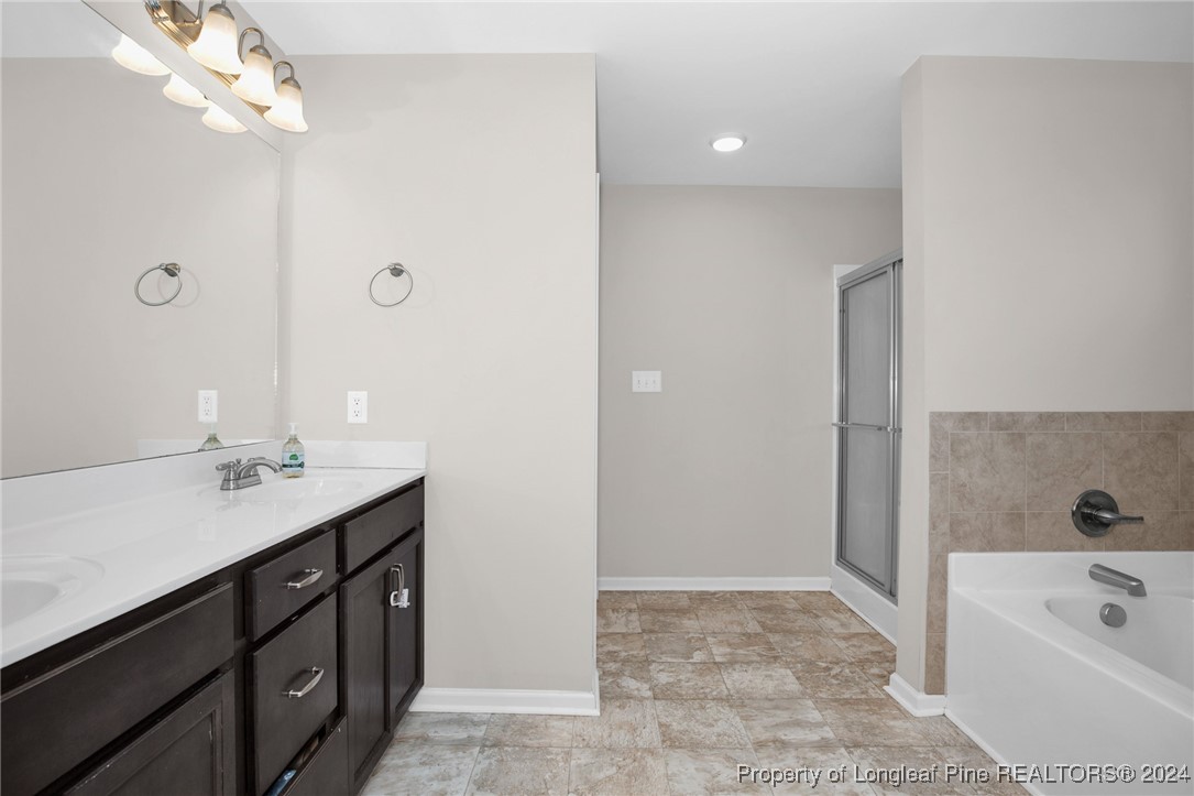 181 Chatfield Dr. Raeford, NC 28376 - Photo 19 of 36 a spacious bathroom with a tub sink and mirror