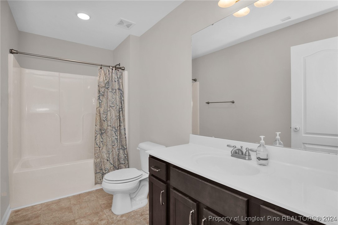181 Chatfield Dr. Raeford, NC 28376 - Photo 28 of 36 a bathroom with a sink a toilet a mirror and shower