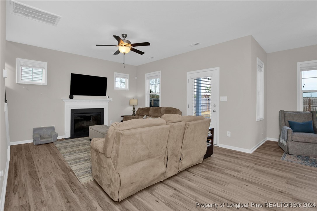 181 Chatfield Dr. Raeford, NC 28376 - Photo 6 of 36 a living room with furniture a fireplace and a flat screen tv