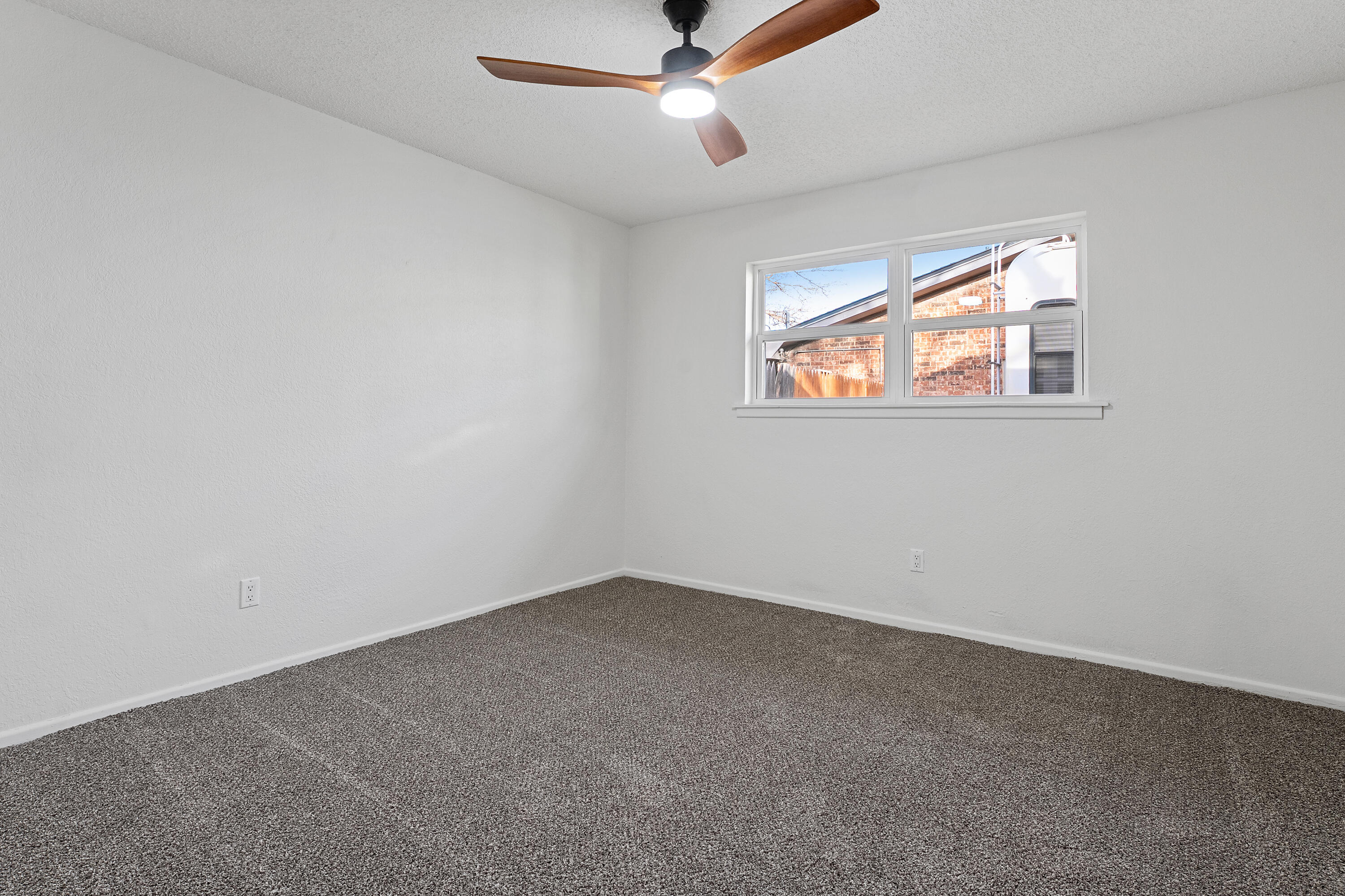1117 15th Street Shallowater, TX 79363 - Photo 16 of 23 an empty room with windows and ceiling fan