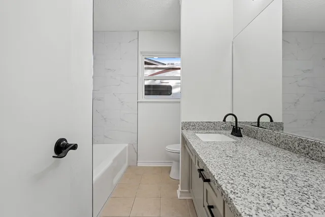a bathroom with a granite countertop sink and mirror