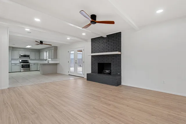 a view of empty room with wooden floor and fireplace