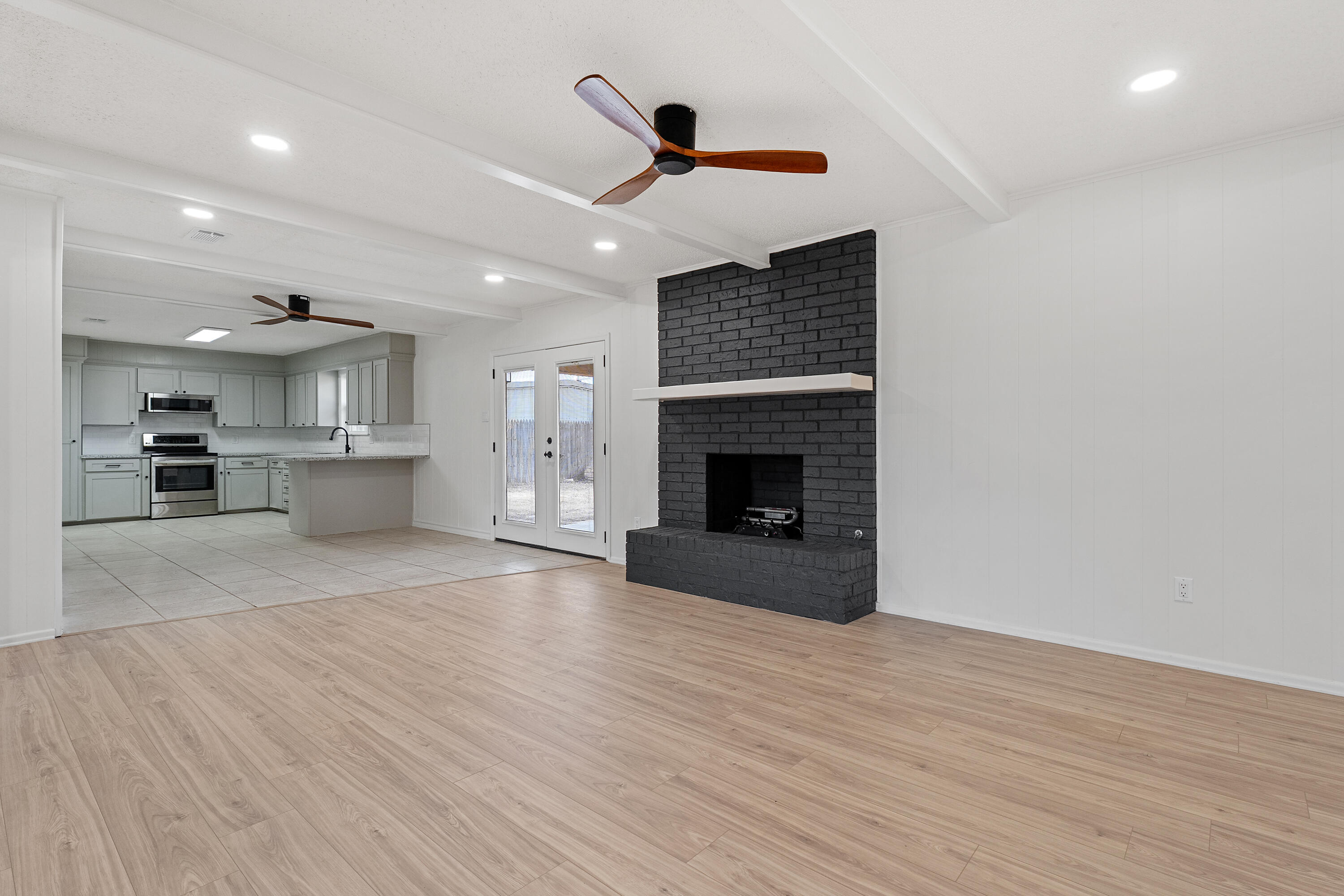 1117 15th Street Shallowater, TX 79363 - Photo 4 of 23 a view of empty room with wooden floor and fireplace