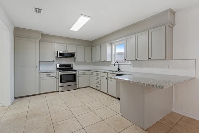 a kitchen with granite countertop cabinets and white stainless steel appliances