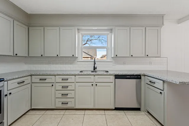 a kitchen with cabinets appliances a sink and a counter top
