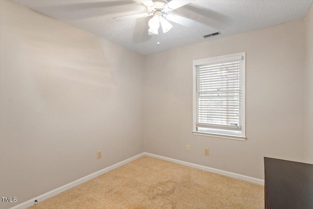 721 Tan Tara Square Raleigh, NC 27615 - Photo 15 of 26 an empty room with a window and a fan