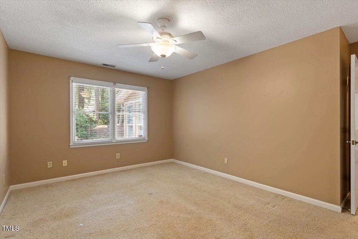 721 Tan Tara Square Raleigh, NC 27615 - Photo 19 of 26 an empty room with a chandelier fan and window