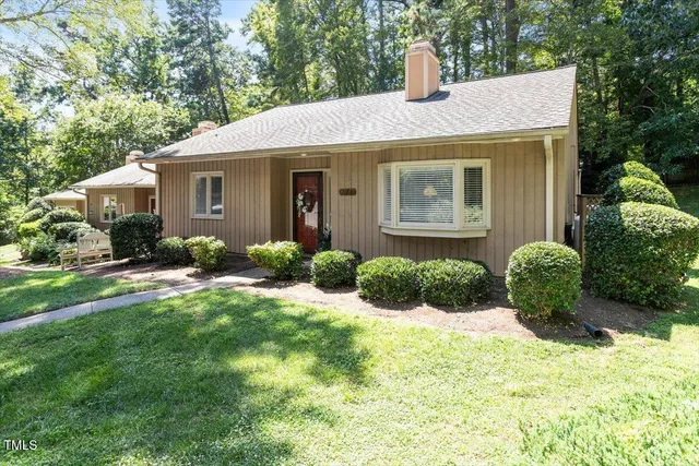 a front view of a house with yard and green space