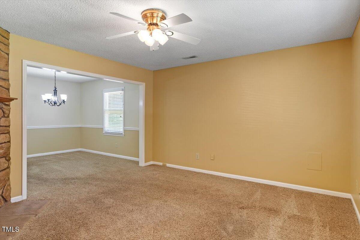 721 Tan Tara Square Raleigh, NC 27615 - Photo 6 of 26 an empty room with a chandelier fan and windows