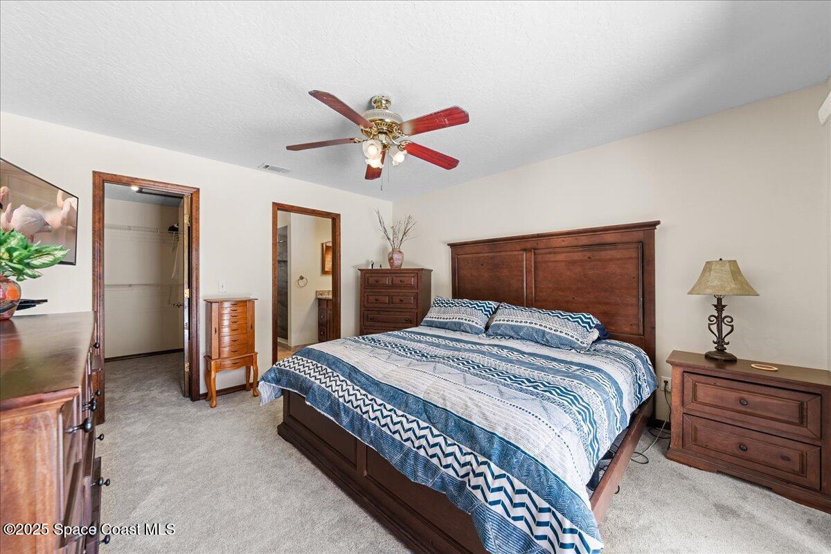 257 Avens Road Northeast Palm Bay, FL 32907 - Photo 17 of 52 a bedroom with a bed and a chandelier