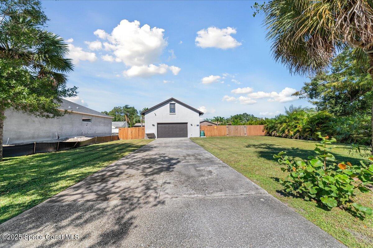 257 Avens Road Northeast Palm Bay, FL 32907 - Photo 31 of 52 a front view of house with yard and green space
