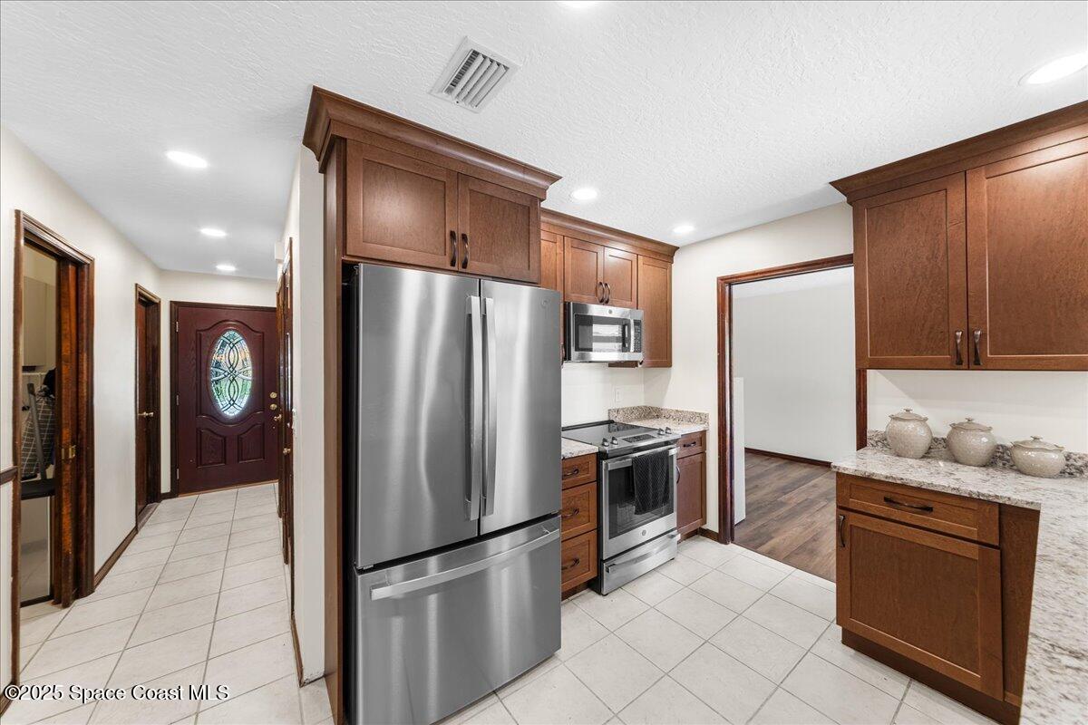 257 Avens Road Northeast Palm Bay, FL 32907 - Photo 5 of 52 a kitchen with stainless steel appliances granite countertop a refrigerator and a stove