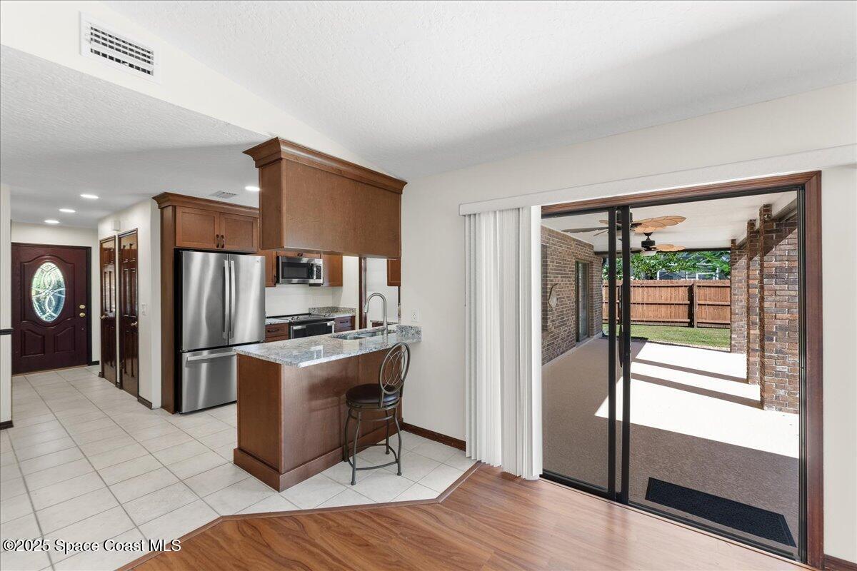 257 Avens Road Northeast Palm Bay, FL 32907 - Photo 6 of 52 a kitchen with stainless steel appliances granite countertop a refrigerator and a stove top oven