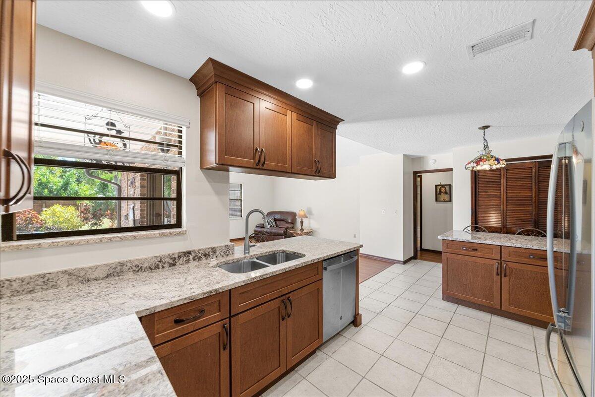 257 Avens Road Northeast Palm Bay, FL 32907 - Photo 8 of 52 a kitchen with stainless steel appliances granite countertop a sink stove and refrigerator