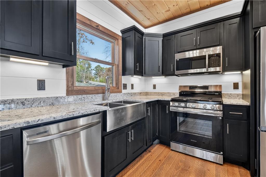 142 Red Oak Trail Ellijay, GA 30540 - Photo 15 of 63 a kitchen with stainless steel appliances granite countertop a stove microwave and sink