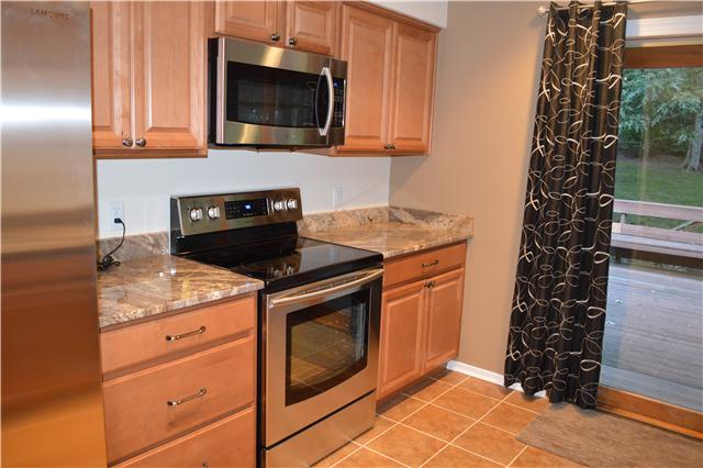 208 Turtle Neck Road Fairview, TN 37062 - Photo 6 of 20 a kitchen with granite countertop a stove top oven microwave and cabinets