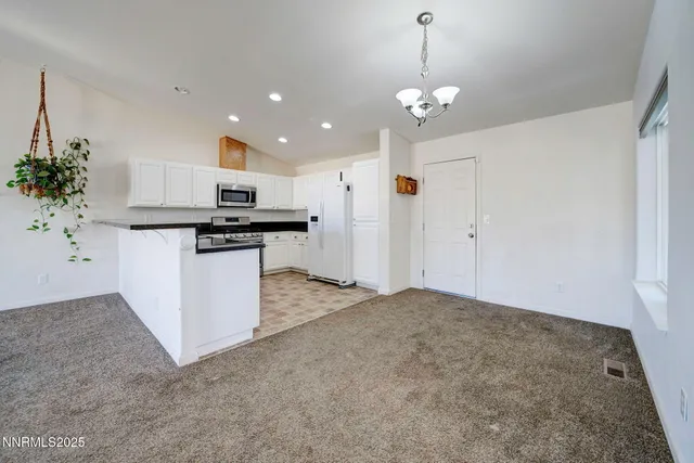 a open kitchen with kitchen island a stove a refrigerator a sink dishwasher with a dining table and chairs