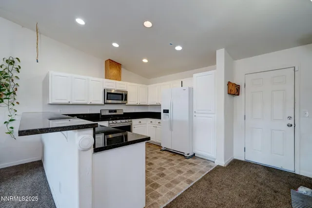 a kitchen with stainless steel appliances granite countertop a sink a stove and microwave