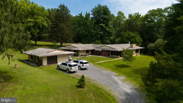 an aerial view of a house with swimming pool garden and patio