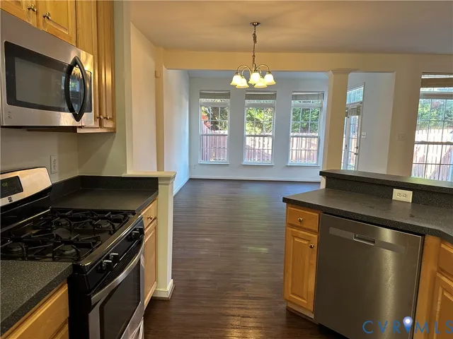 a kitchen with a stove a sink and wooden floor