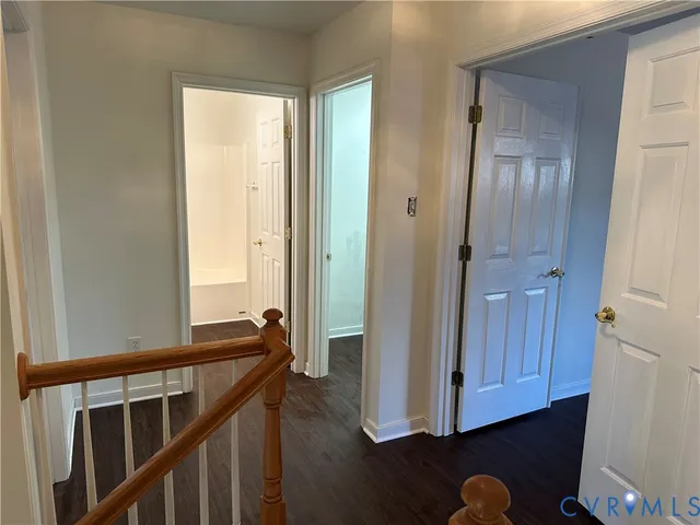 a view of a hallway with wooden floor and closet