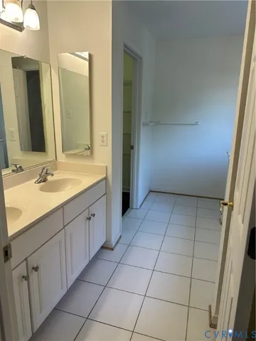 a spacious bathroom with a granite countertop sink a mirror and a bathtub