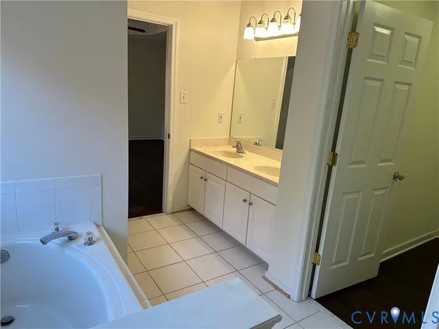 a bathroom with a tub sink and mirror