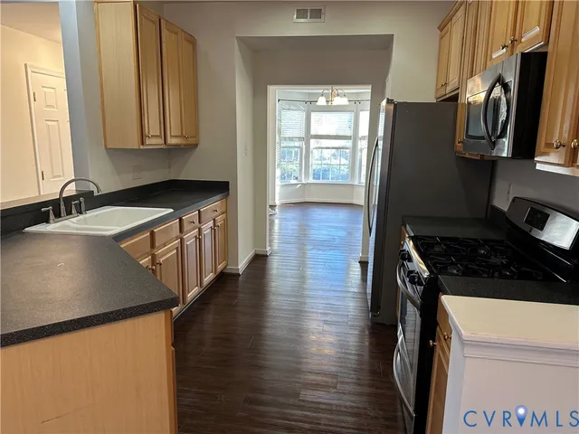 a kitchen with wooden floor and a sink