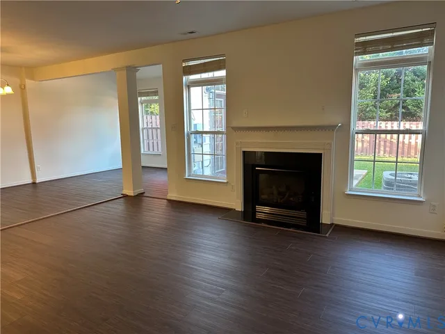 an empty room with floor to ceiling window and fireplace