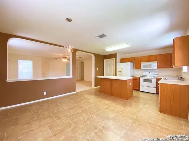 a view of kitchen with stainless steel appliances granite countertop a sink and cabinets