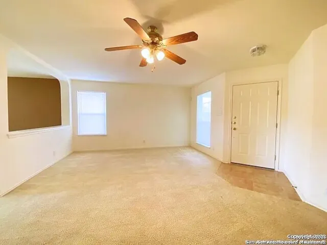 a view of an empty room with a ceiling fan